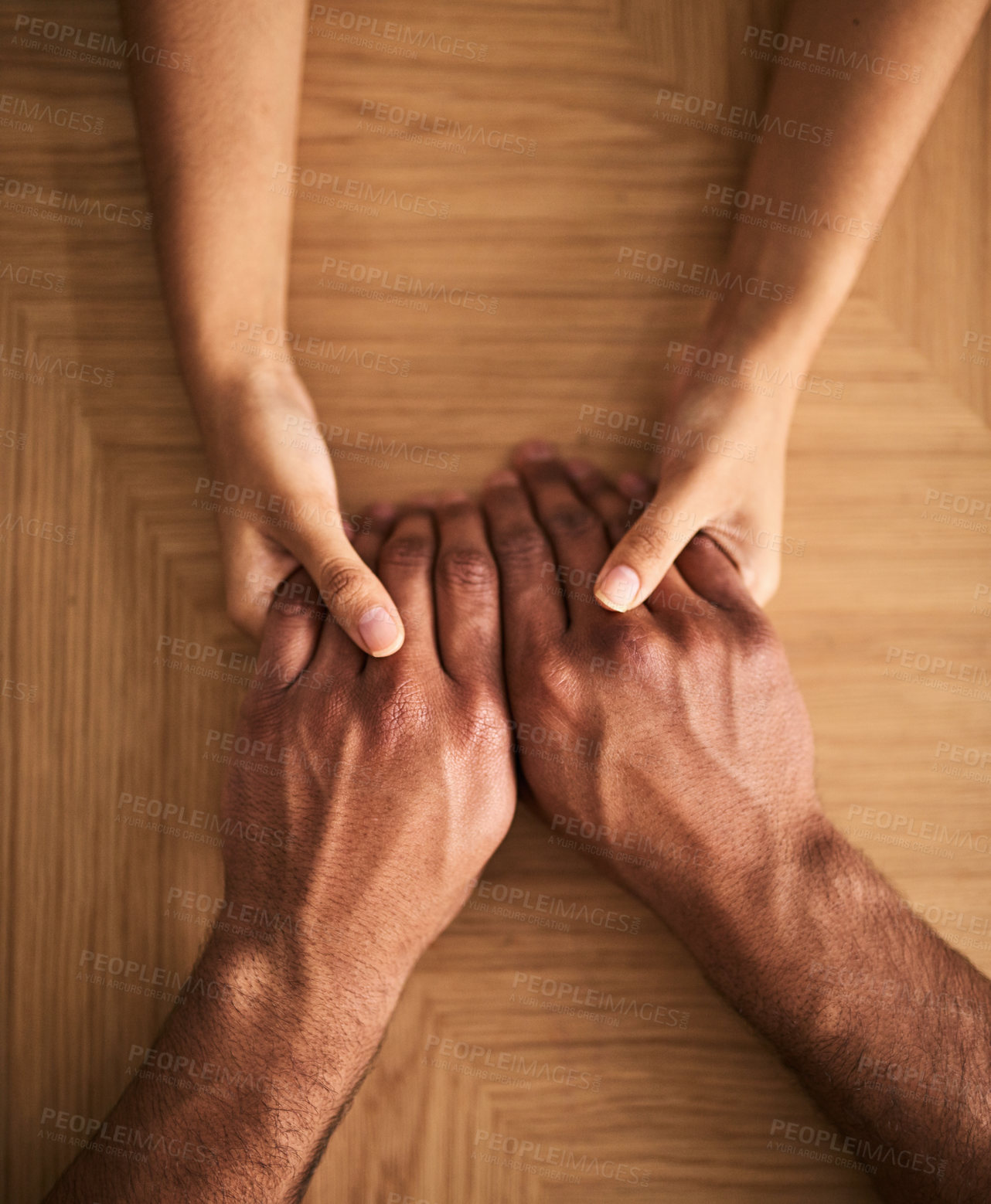 Buy stock photo Man and woman holding hands sharing feelings of love, support and trust together on a table. Closeup of a loving couple expressing care, promise and compassion to overcome problems 