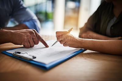 Buy stock photo Cropped shot of a man and woman completing paperwork together at a desk