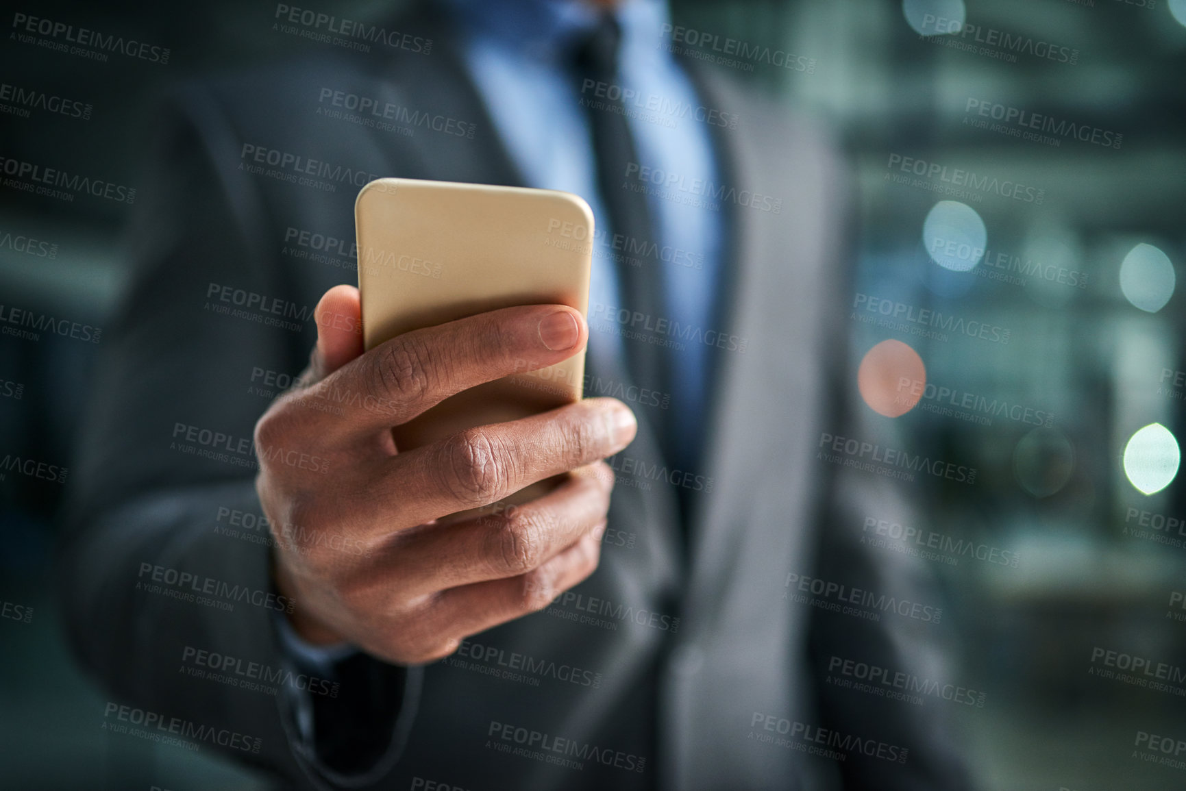 Buy stock photo A phone in hand for texting, communication and networking for business planning, discussion and strategy. Closeup of a corporate professional holding a cellphone while standing on a dark background