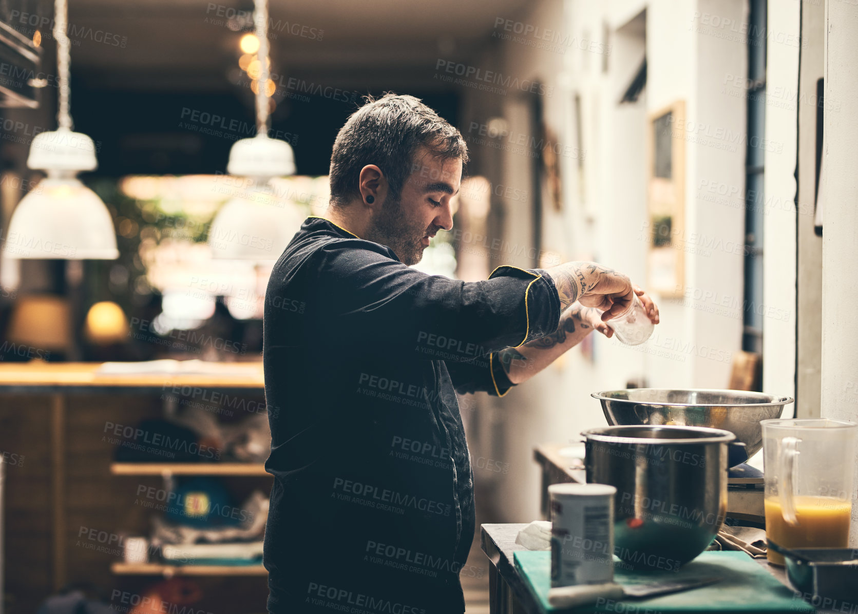 Buy stock photo Shot of a focused chef preparing a dish in the kitchen of a restaurant