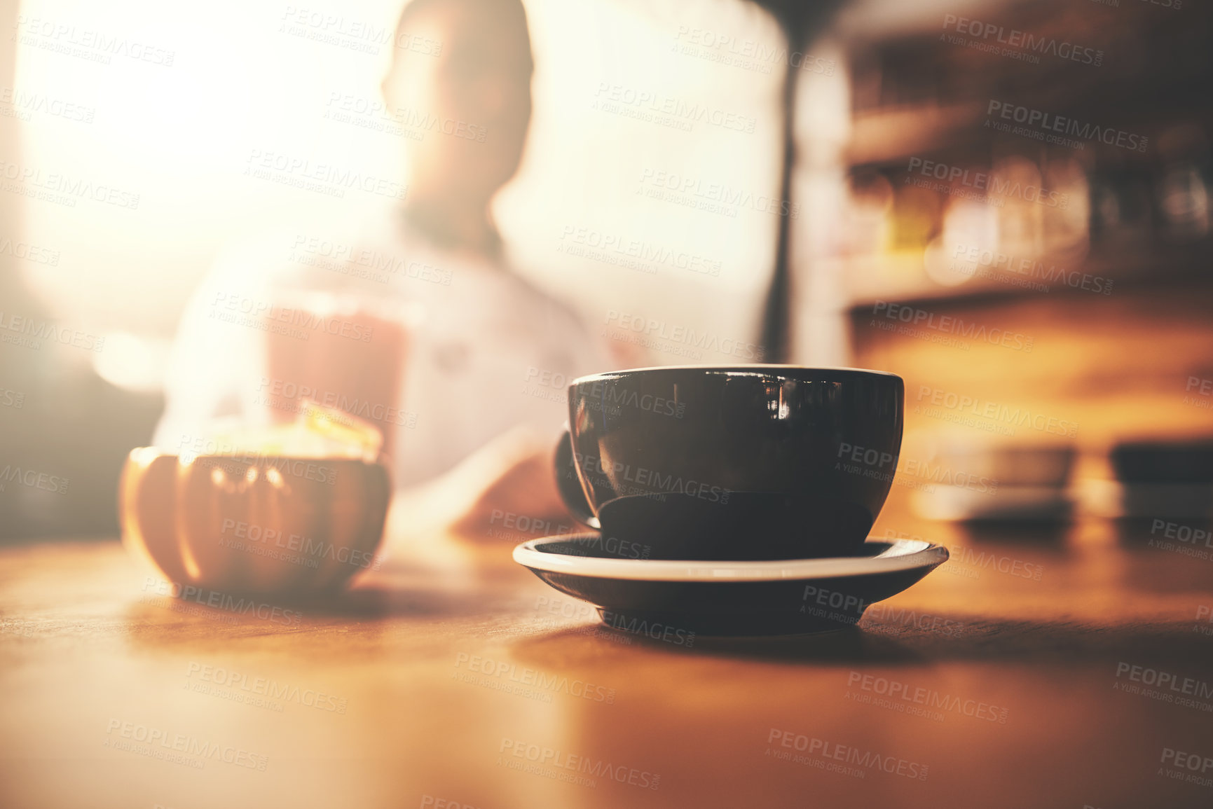 Buy stock photo Restaurant, table and coffee of customer in cup for morning caffeine, hot beverage and service at cafe. Lens flare, cappuccino and hospitality at bistro for lunch break, energy or person at cafeteria