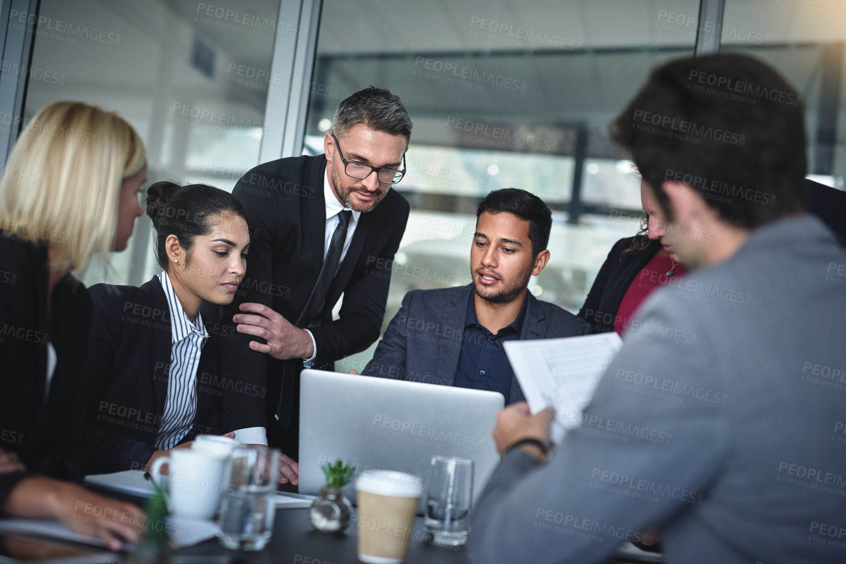 Buy stock photo Shot of a group of businesspeople having a meeting together over a laptop in a boardroom at the office