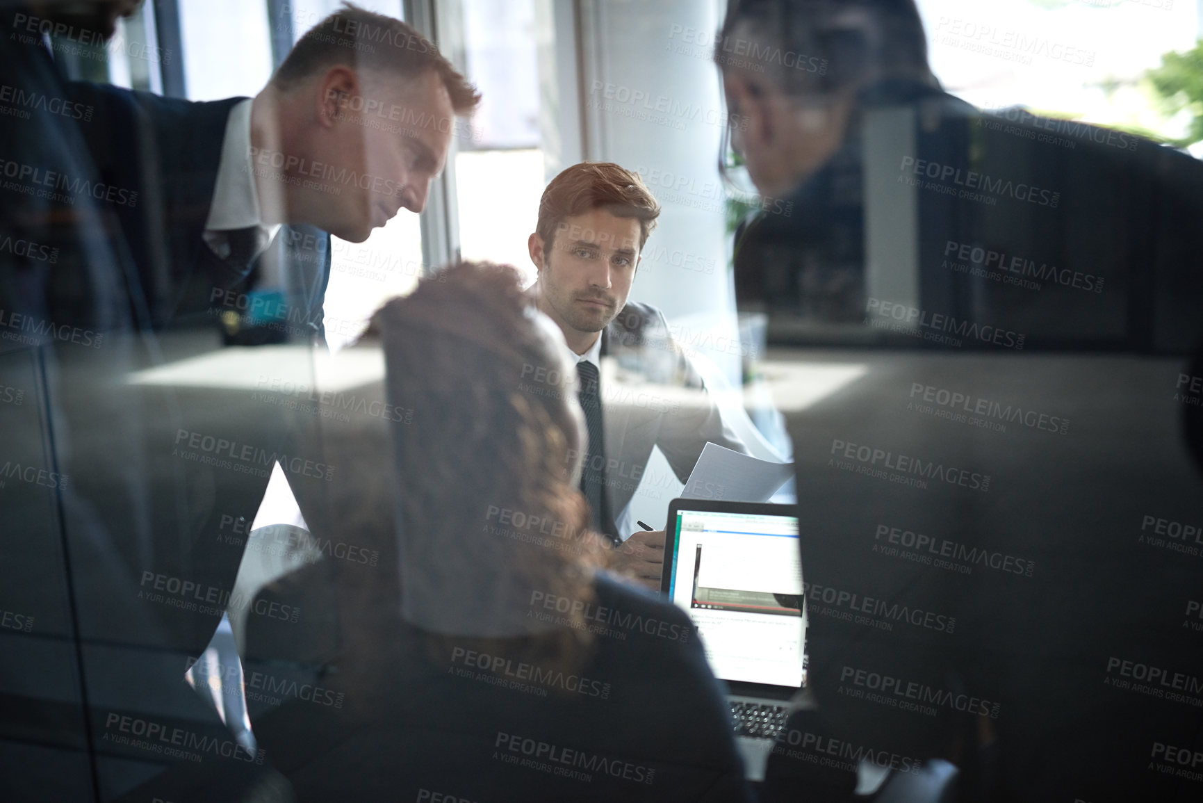 Buy stock photo Rearview shot of a group of businesspeople having a meeting together over a laptop in a boardroom at the office