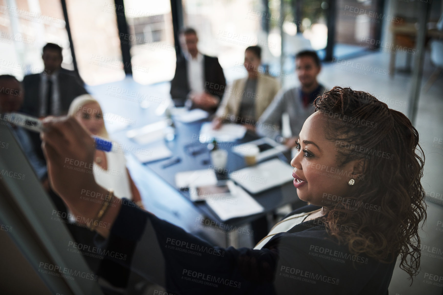 Buy stock photo High angle shot of a young businesswoman explaining work related stuff during a presentation to work colleagues in a boardroom