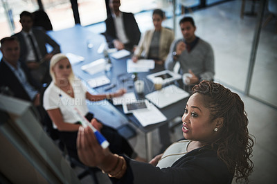 Buy stock photo High angle shot of a young businesswoman explaining work related stuff during a presentation to work colleagues in a boardroom