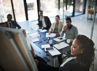 Buy stock photo High angle shot of a young businesswoman explaining work related stuff during a presentation to work colleagues in a boardroom