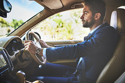 Buy stock photo Shot of a cheerful young businessman driving in his car to work while sitting in traffic
