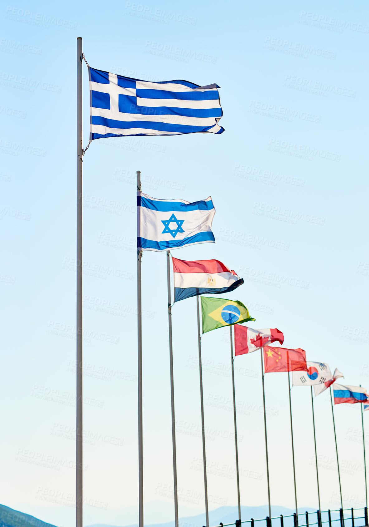 Buy stock photo Shot of a variety of different kinds of country's flags standing next to each other outside during the day