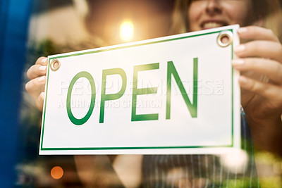 Buy stock photo Shot of an unrecognizable woman holding up a open sign at a bar
