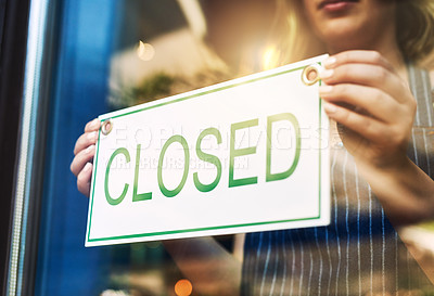 Buy stock photo Shot of a woman putting up a closed sign in a bar