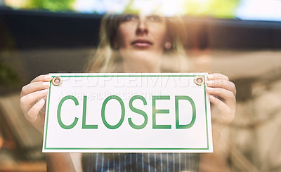 Buy stock photo Shot of a woman putting up a closed sign in a bar