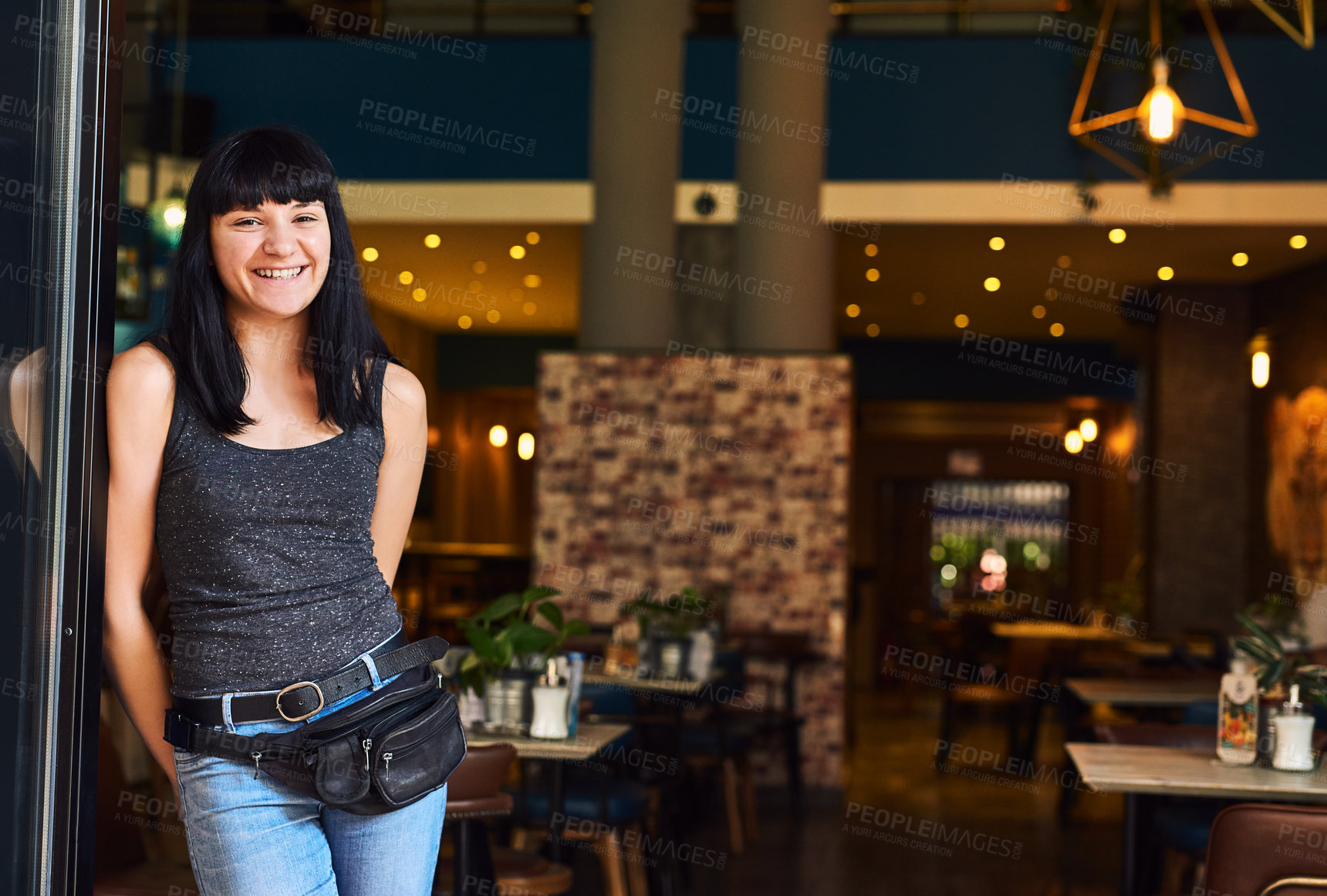 Buy stock photo Shot of a waitress standing at the entrance of a bar