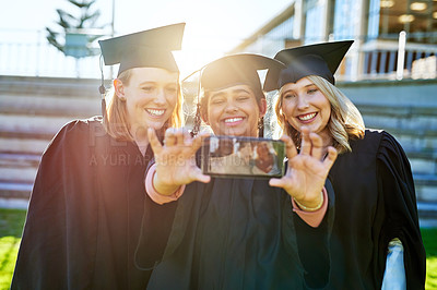 Buy stock photo Shot of a group of students taking a selfie together on graduation day