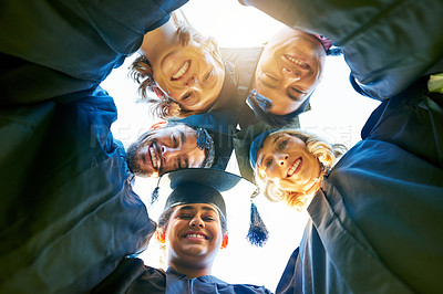 Buy stock photo Portrait of a group of students standing in a huddle with their heads together on graduation day