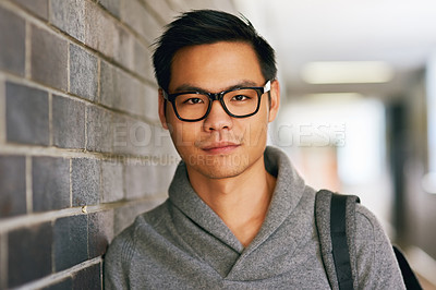 Buy stock photo Cropped portrait of a handsome young male university student standing in a campus corridor