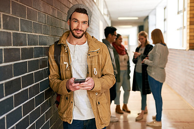 Buy stock photo Portrait of a young male university student standing in a campus corridor with his classmates in the background