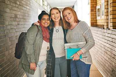 Buy stock photo Portrait of three attractive young female university students standing in a campus corridor