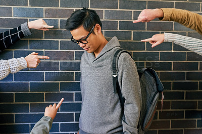 Buy stock photo Cropped shot of a young male university student being bullied while standing in a campus corridor