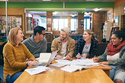 Buy stock photo Shot of a cheerful young group of students studying together while having a discussion inside of a library