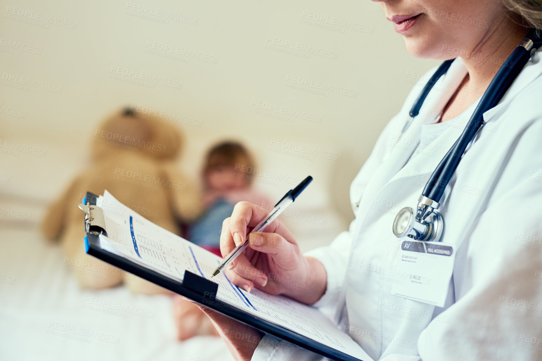 Buy stock photo Cropped shot of a doctor filling out a form while treating a child patient