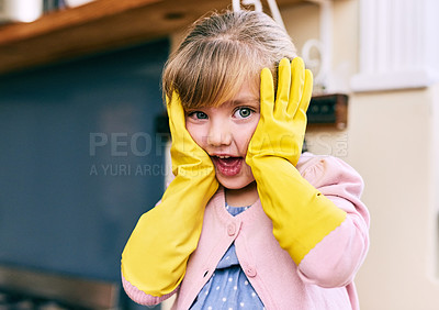 Buy stock photo Portrait of a surprised looking little girl holding her face wit her hands while wearing yellow dishwashing gloves