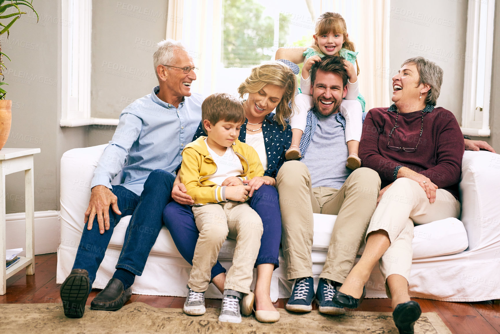 Buy stock photo Family, laughing and happy in house for relax, bonding and support with generations, love and care. Grandparents, father and girl in living room for comfort, relationship or visit together on weekend