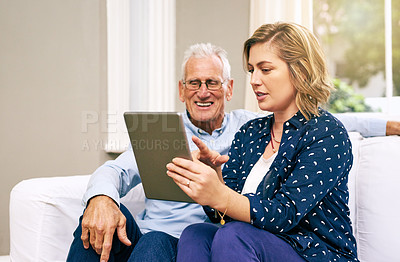Buy stock photo Shot of a senior father and his adult daughter using a tablet together at home