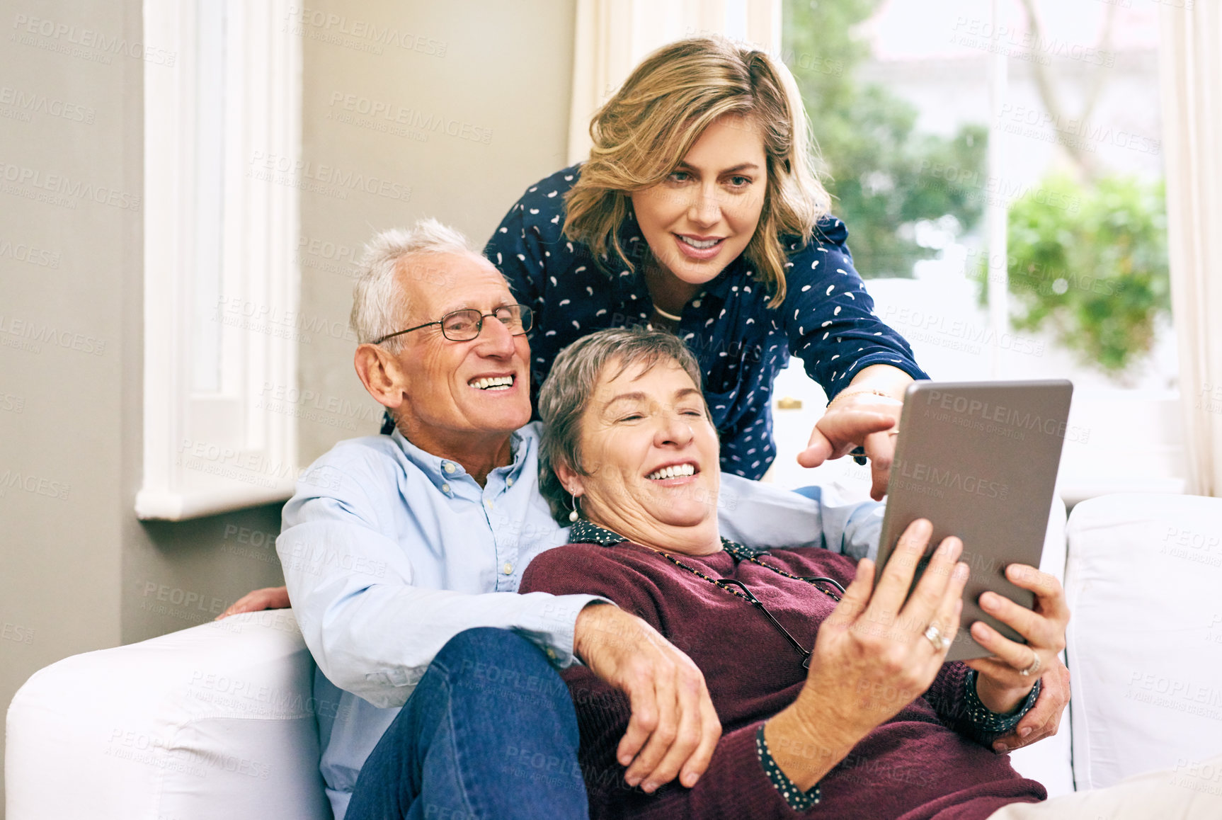Buy stock photo Woman, tablet and elderly couple on sofa for help, learning and showing new app at home. Senior parents, daughter and tech in living room for communication, streaming and relax on couch with media