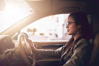 Buy stock photo Shot of a young businesswoman driving a car