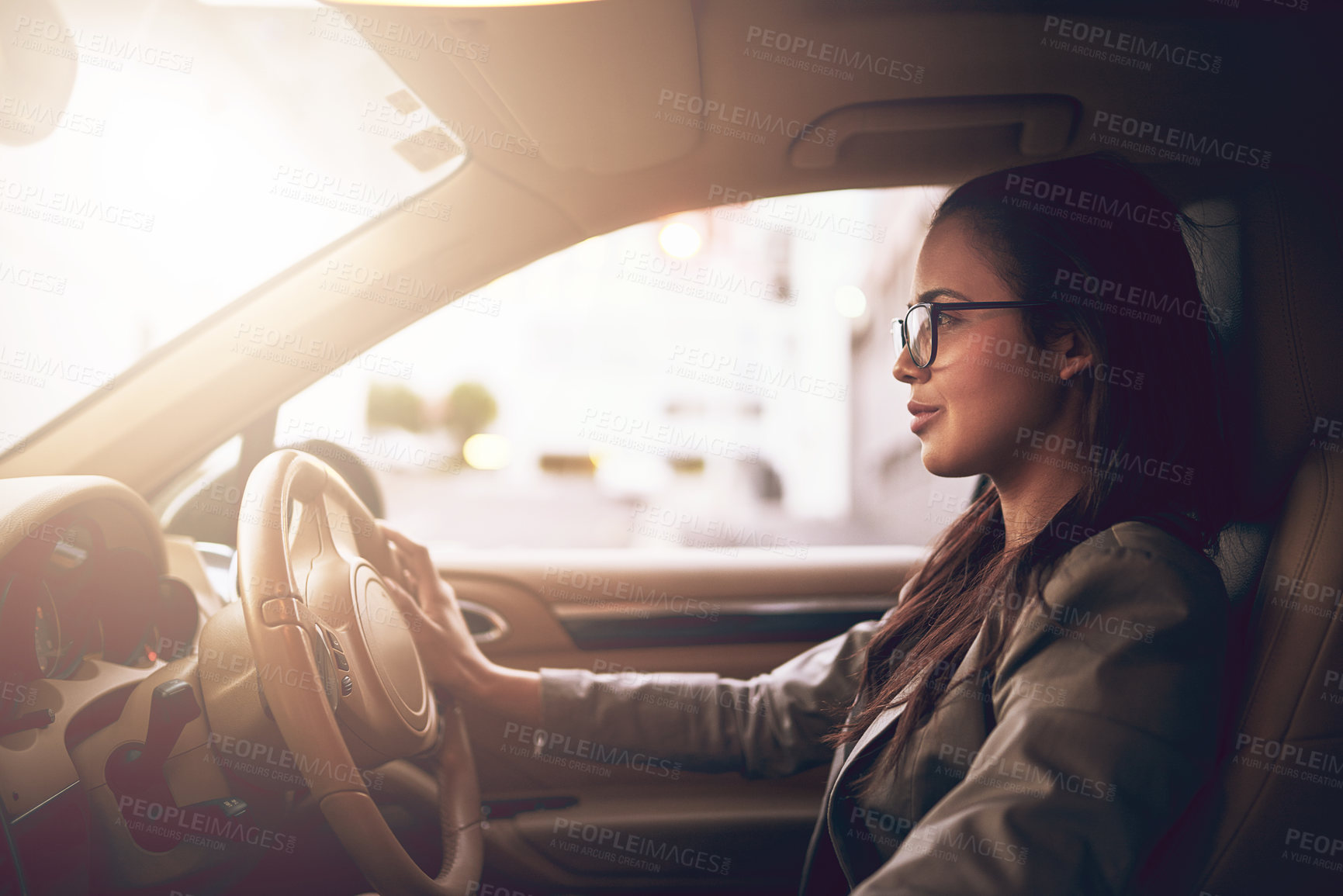 Buy stock photo Shot of a young businesswoman driving a car