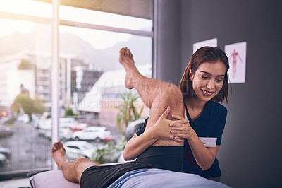 Buy stock photo Cropped shot of a young female physiotherapist treating a male patient