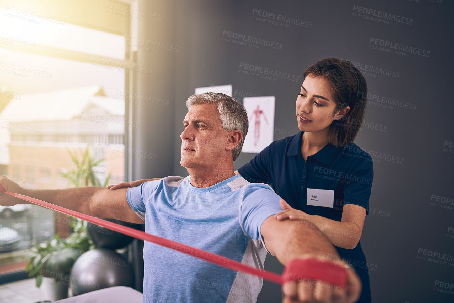 Buy stock photo Cropped shot of a young female physiotherapist treating a mature male patient