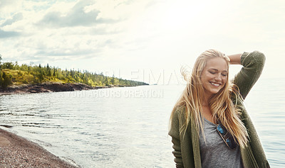 Buy stock photo Shot of a young woman spending a day at the lake