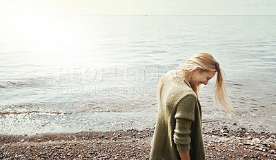 Buy stock photo Shot of a young woman spending a day at the lake