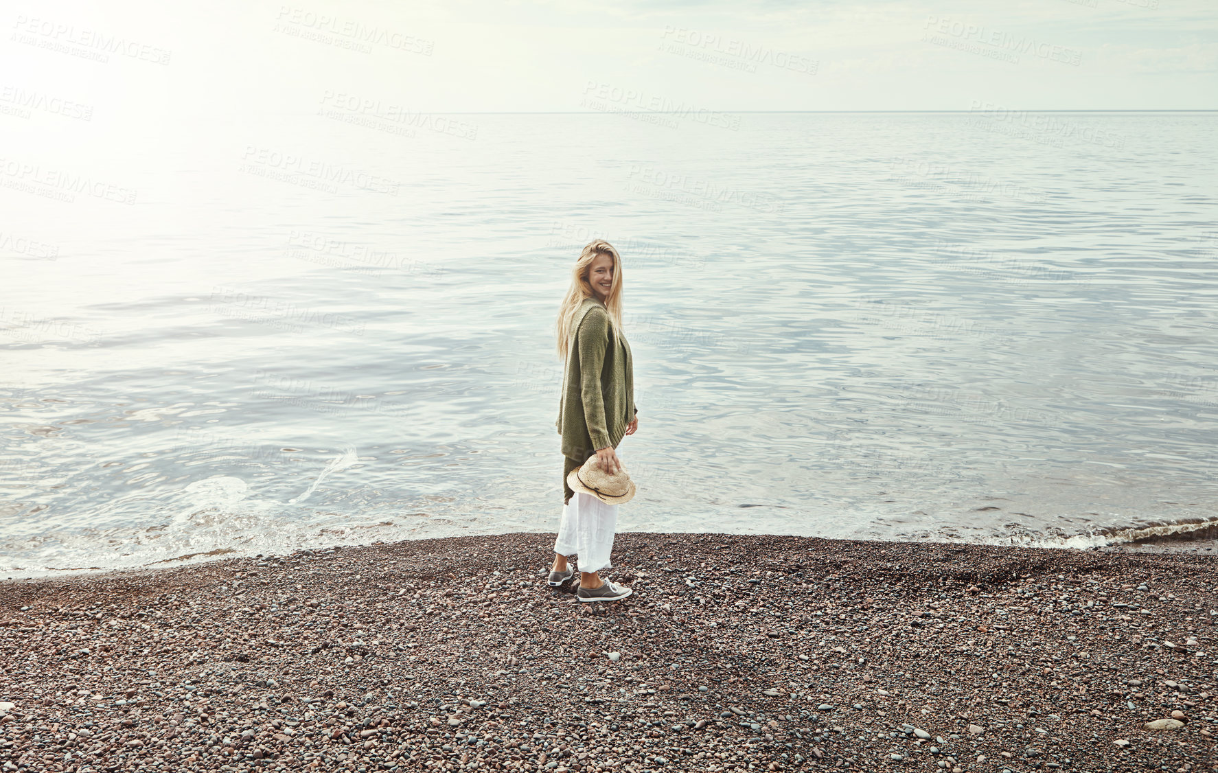 Buy stock photo Shot of a young woman spending a day at the lake