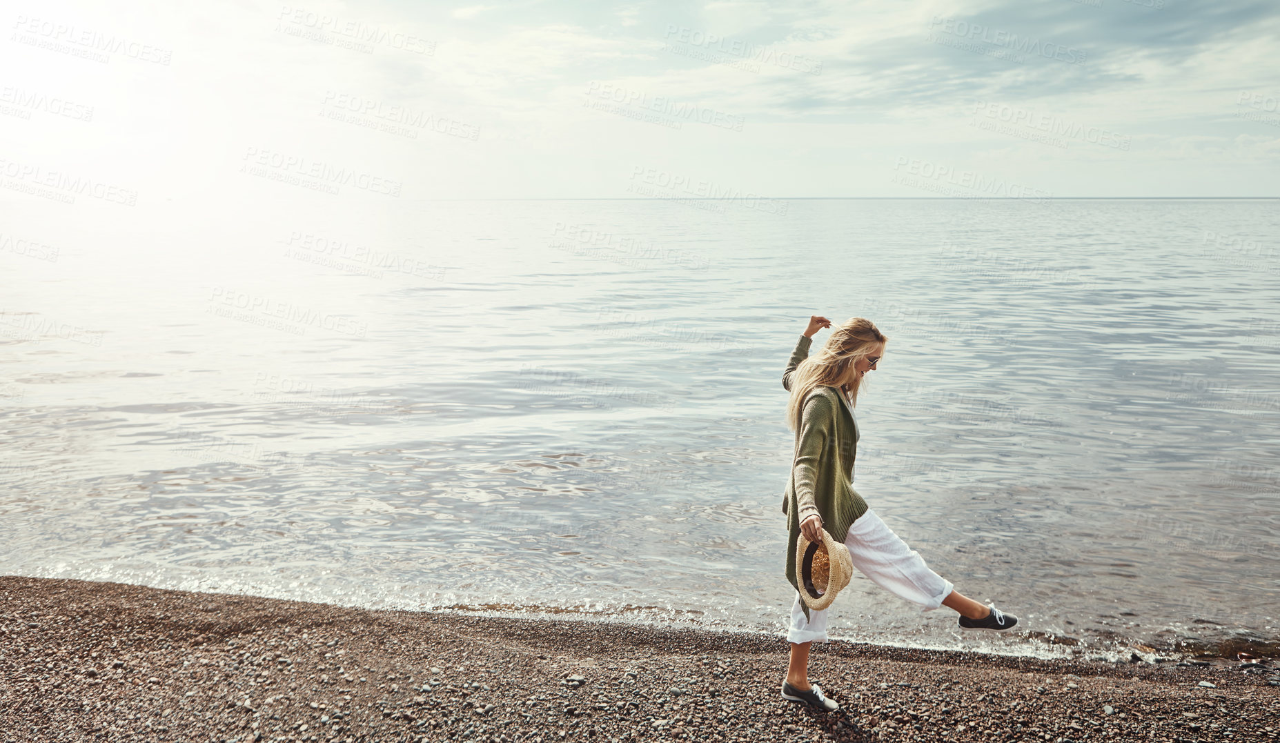 Buy stock photo Shot of a young woman spending a day at the lake
