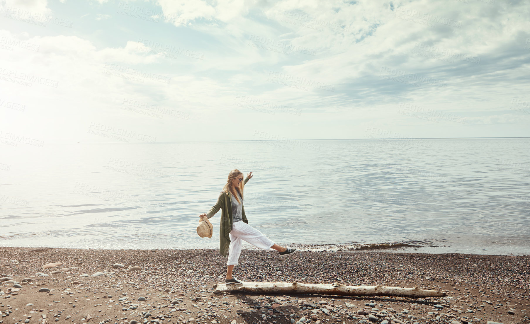 Buy stock photo Happy, log and woman at lake, travel and holiday for weekend break, water and peaceful. Outdoor, tourism and person with nature, vacation and adventure with freedom, balance or journey in Canada