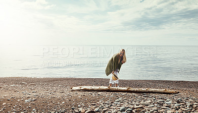 Buy stock photo Shot of a young woman walking along a log at a lake