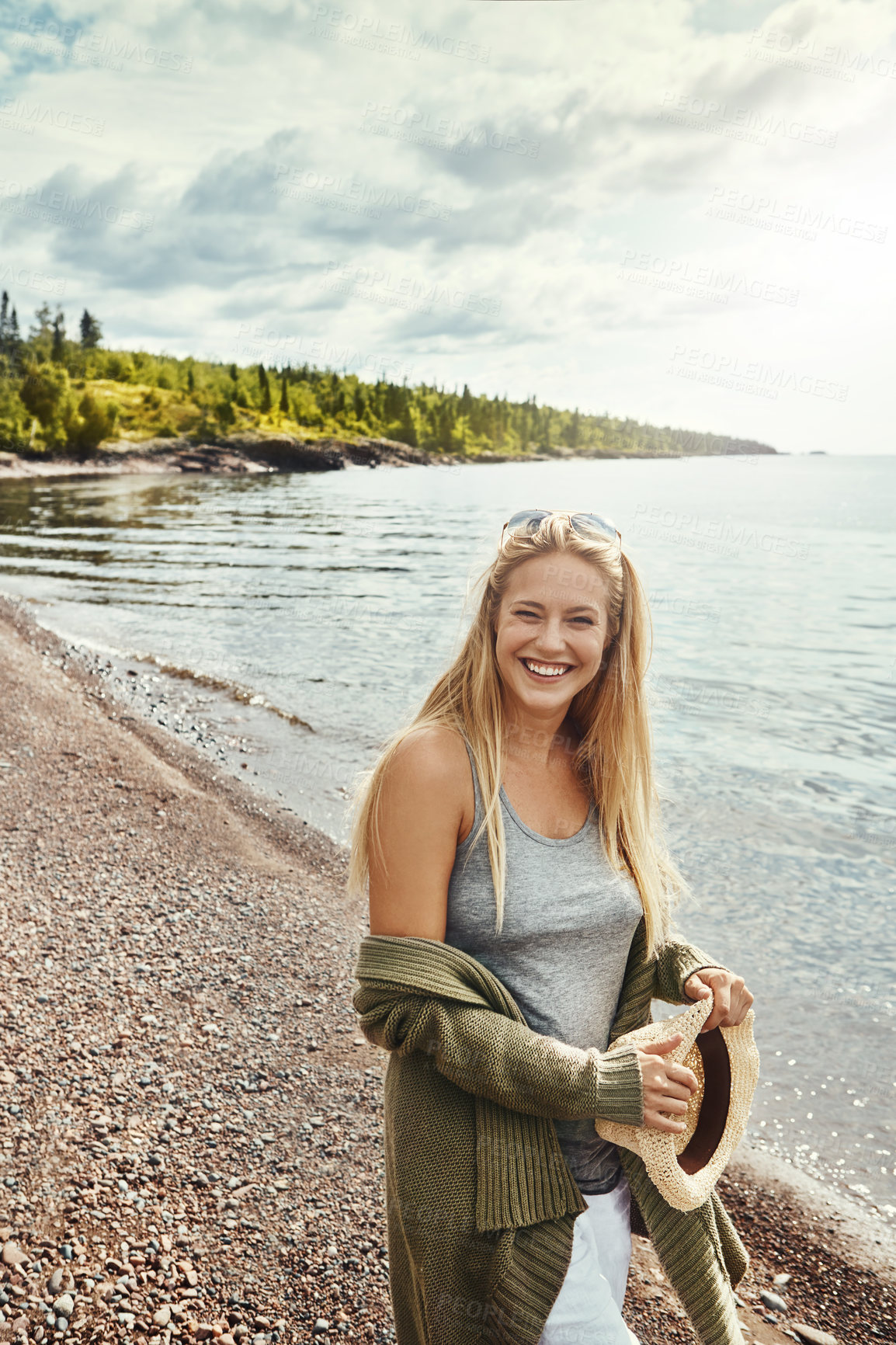 Buy stock photo Shot of a young woman spending a day at the lake