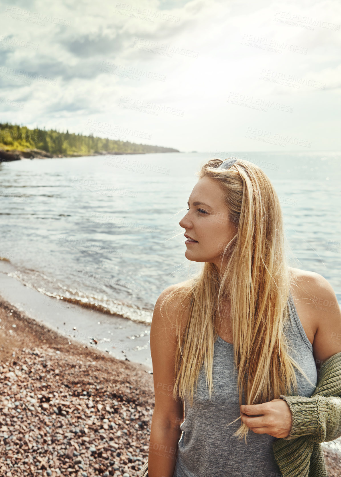 Buy stock photo Shot of a young woman spending a day at the lake