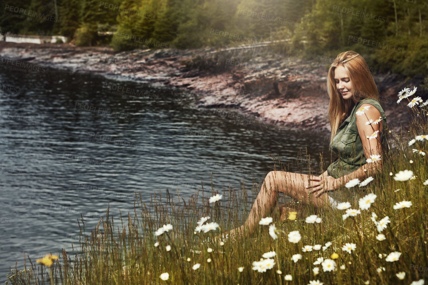 Buy stock photo Shot of an attractive young woman spending a day at the lake