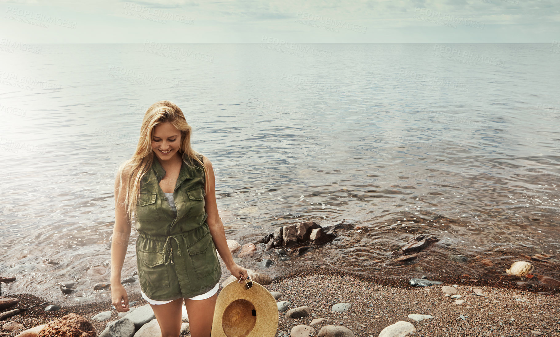 Buy stock photo Shot of an attractive young woman spending a day at the lake