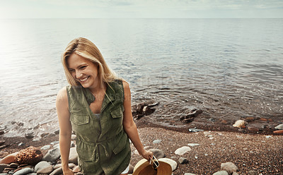 Buy stock photo Shot of an attractive young woman spending a day at the lake