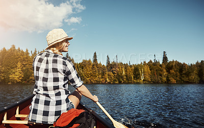 Buy stock photo Shot of an attractive young woman spending a day kayaking on the lake