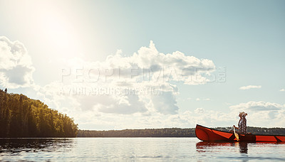 Buy stock photo Shot of an attractive young woman spending a day kayaking on the lake