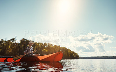 Buy stock photo Shot of an attractive young woman spending a day kayaking on the lake