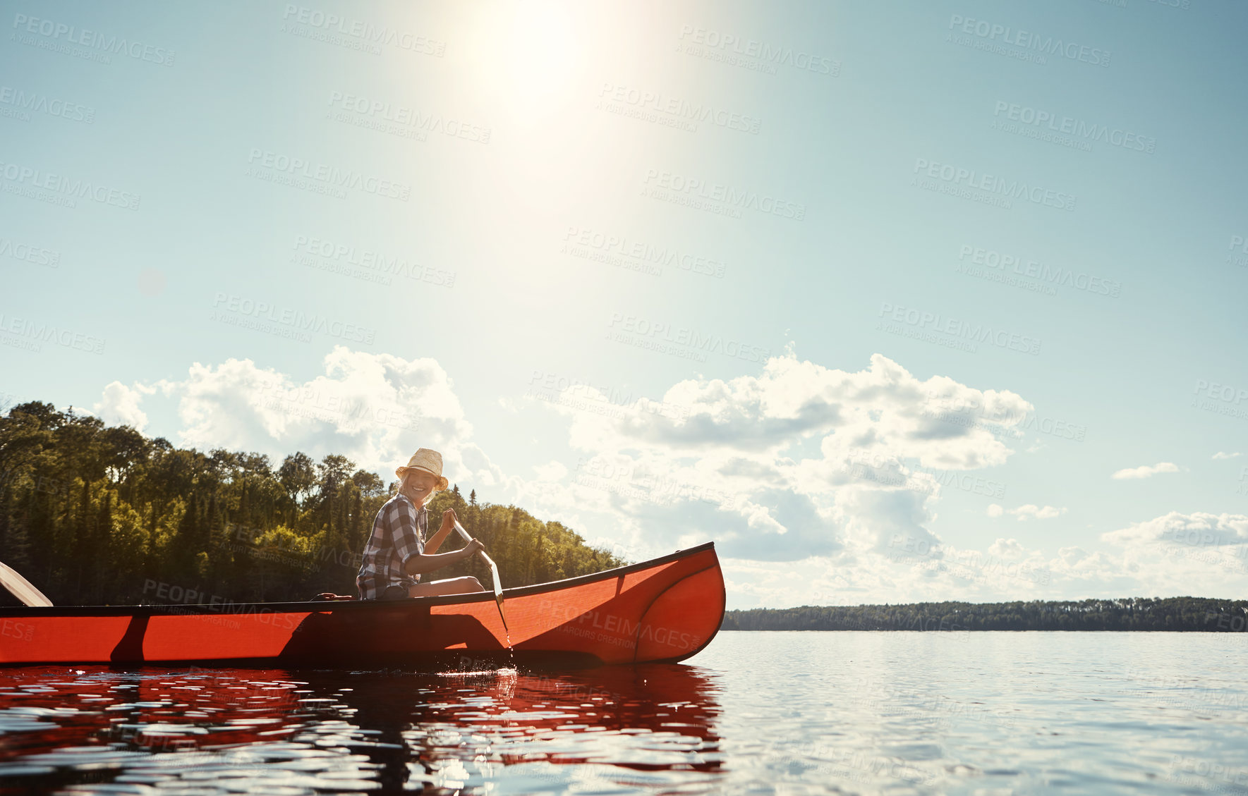 Buy stock photo Shot of an attractive young woman spending a day kayaking on the lake