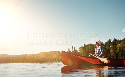 Buy stock photo Shot of an attractive young woman spending a day kayaking on the lake