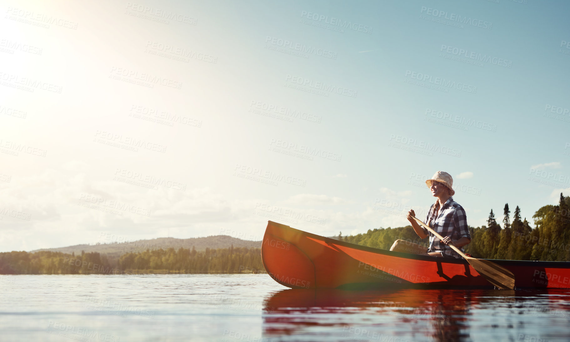 Buy stock photo Shot of an attractive young woman spending a day kayaking on the lake