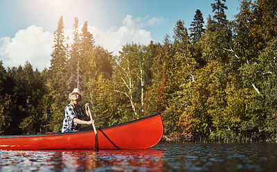 Buy stock photo Shot of an attractive young woman spending a day kayaking on the lake